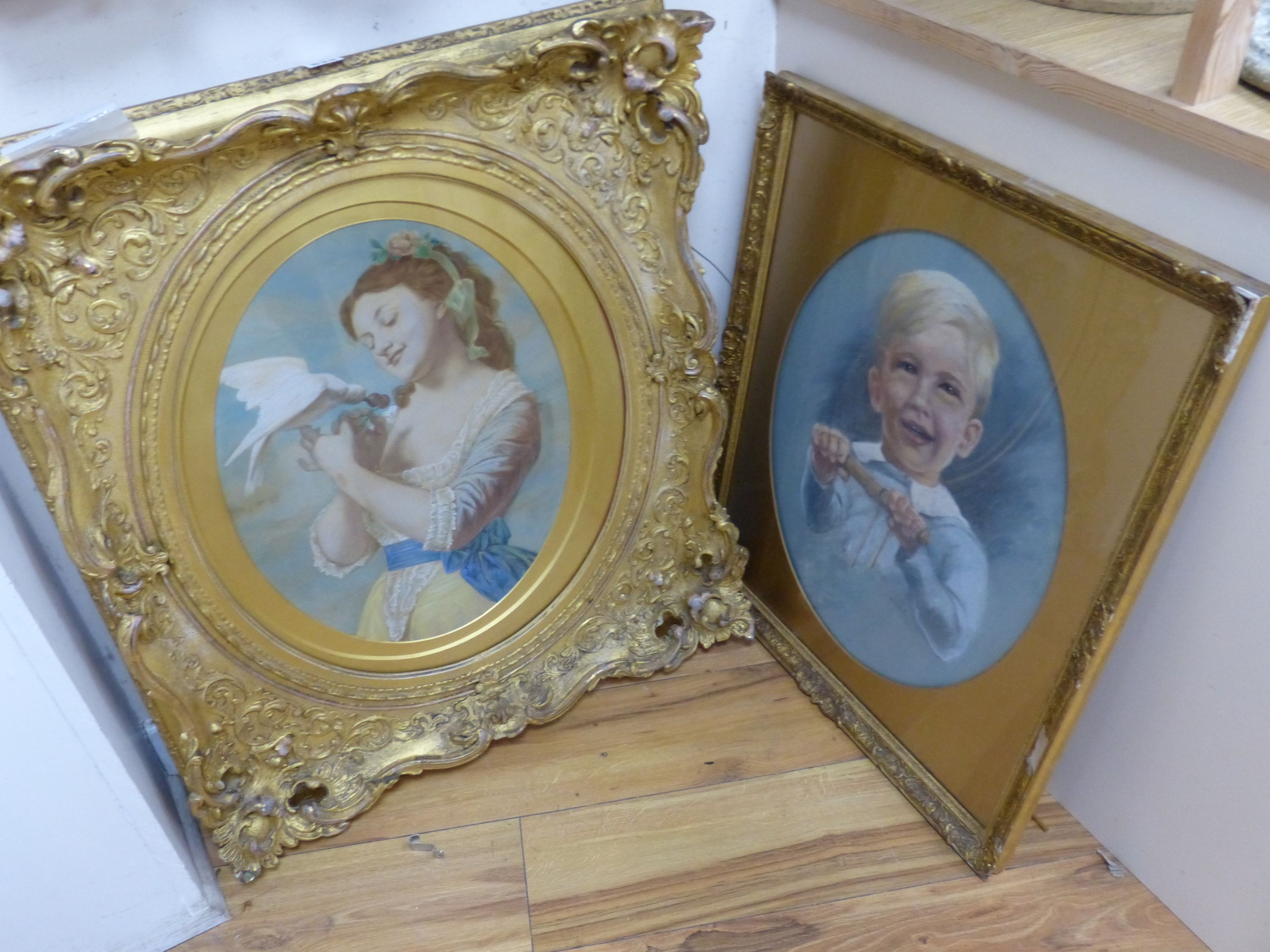 English School c.1900, overpainted print, Young woman with a dove, housed in a Victorian gilt gesso scroll frame, oval, 47 x 36cm, frame overall 76 x 66cm and a pastel portrait of a boy